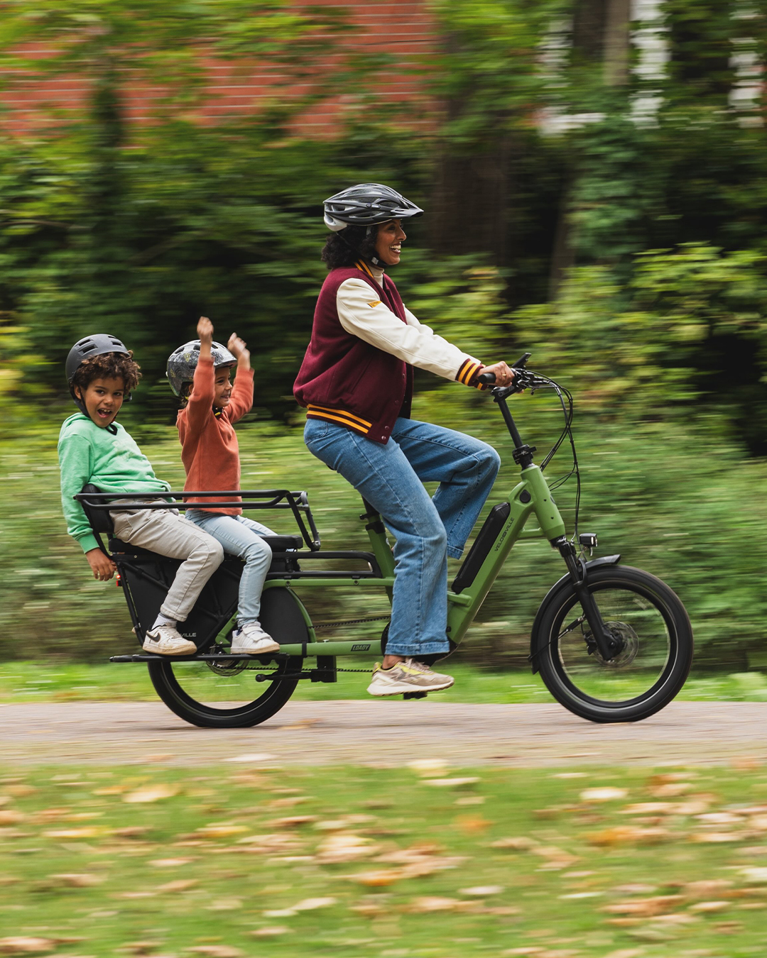 O mamă și doi copii pe un longtail electric VELO DE VILLE LOADY